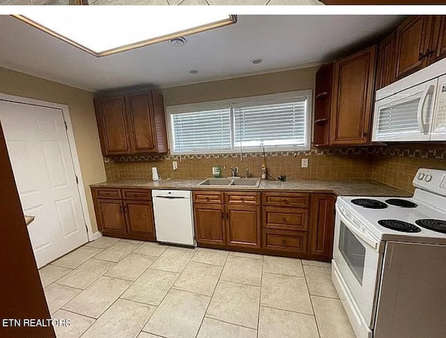 kitchen featuring white appliances, light tile patterned floors, tasteful backsplash, and sink