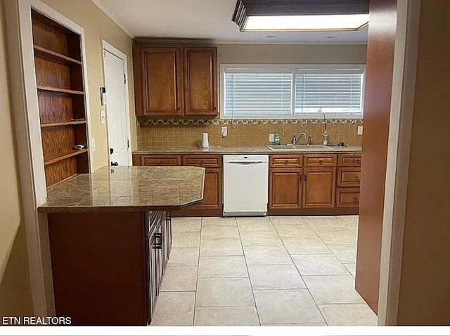 kitchen featuring decorative backsplash, dishwasher, sink, and light tile patterned floors