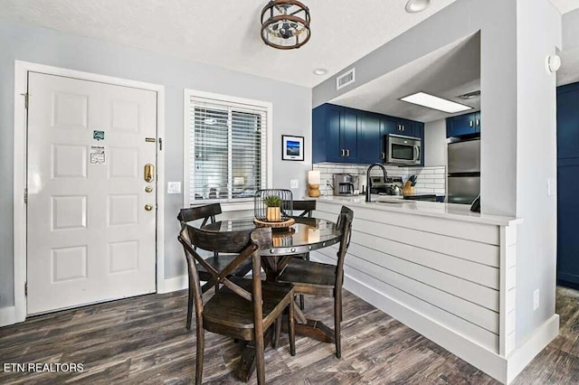 dining area with sink and dark wood-type flooring