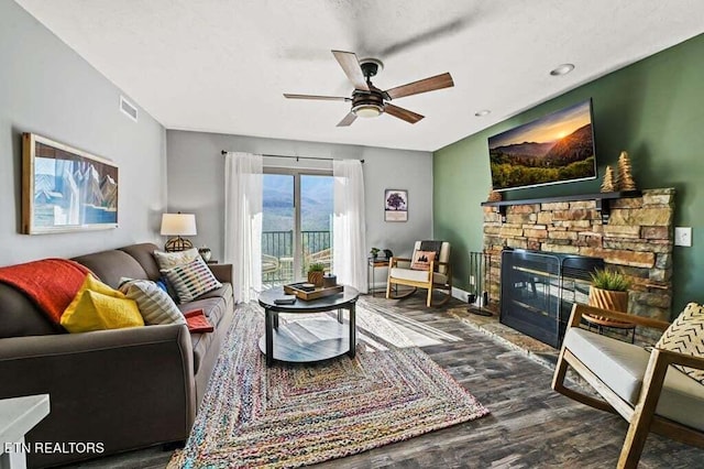 living room with dark hardwood / wood-style floors, a fireplace, and ceiling fan