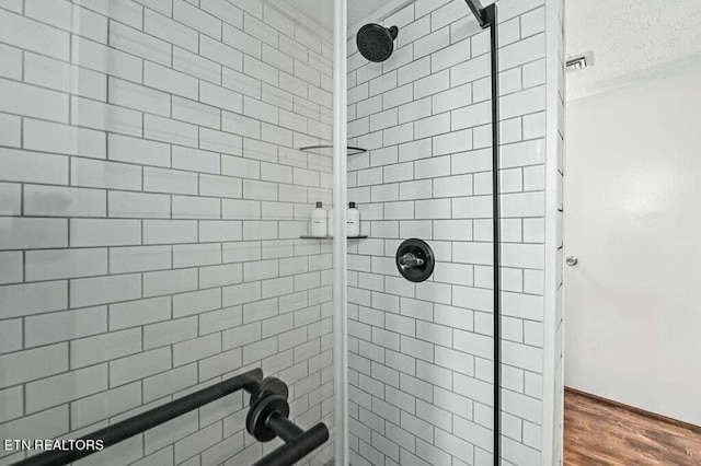 bathroom featuring a tile shower and hardwood / wood-style flooring