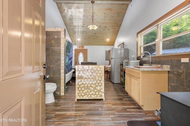 kitchen featuring stainless steel refrigerator, wooden ceiling, tile walls, and vaulted ceiling