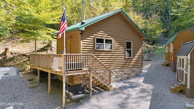 rear view of property featuring a wooden deck