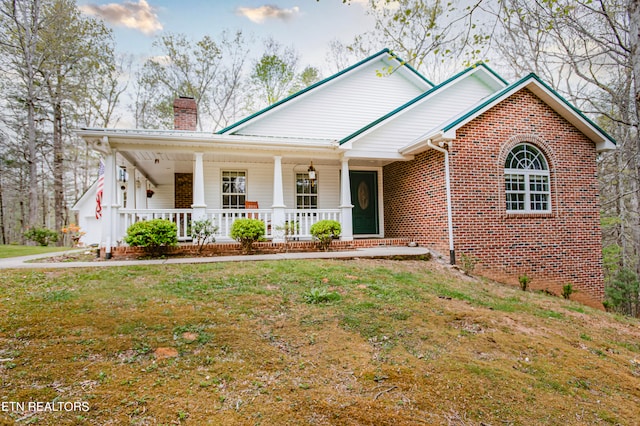 view of front of property featuring covered porch and a front yard