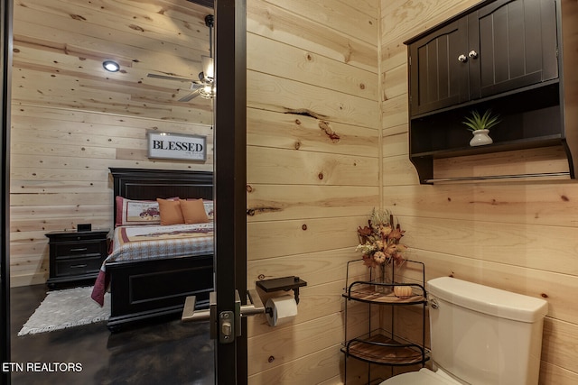 bedroom with ceiling fan and wooden walls