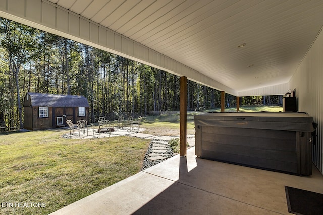 view of patio / terrace with a storage shed and a hot tub