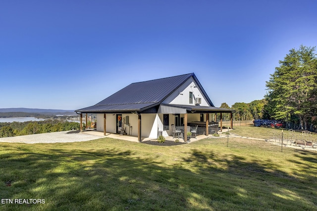 rear view of property featuring a yard and a mountain view