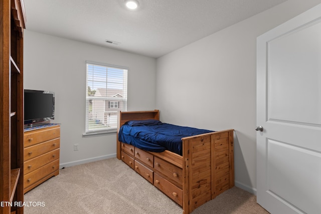 carpeted bedroom featuring a textured ceiling