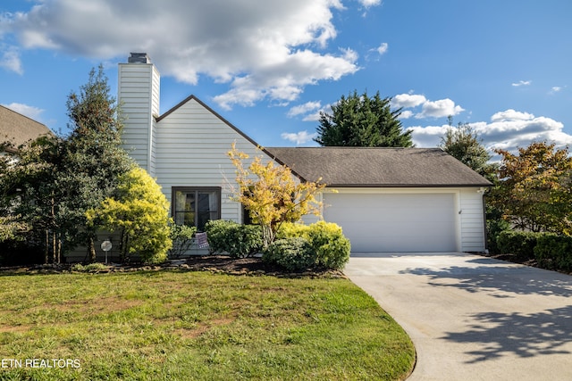 view of front of home with a front yard and a garage