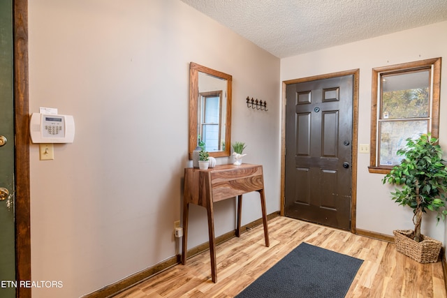 foyer featuring a textured ceiling and light hardwood / wood-style flooring