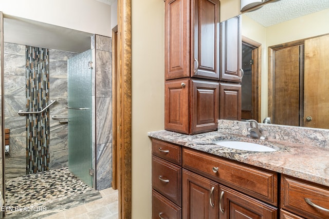 bathroom with vanity, a textured ceiling, and an enclosed shower