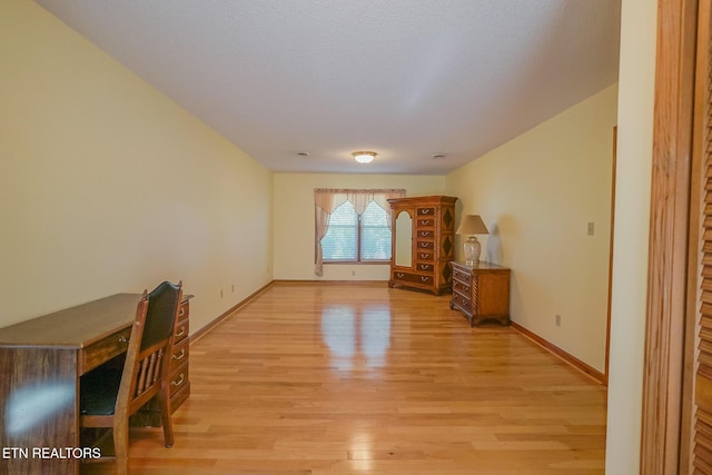 unfurnished room featuring light wood finished floors and baseboards