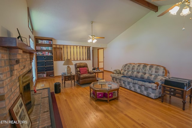 living room with high vaulted ceiling, a ceiling fan, a fireplace, wood finished floors, and beamed ceiling
