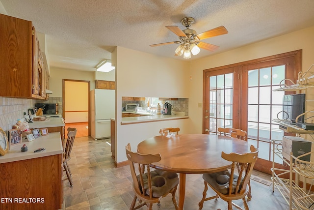 dining area with a textured ceiling and a ceiling fan
