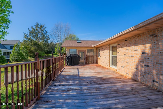 wooden deck featuring a grill