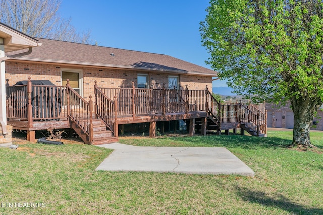 back of house with a patio area, stairway, a deck, brick siding, and a lawn