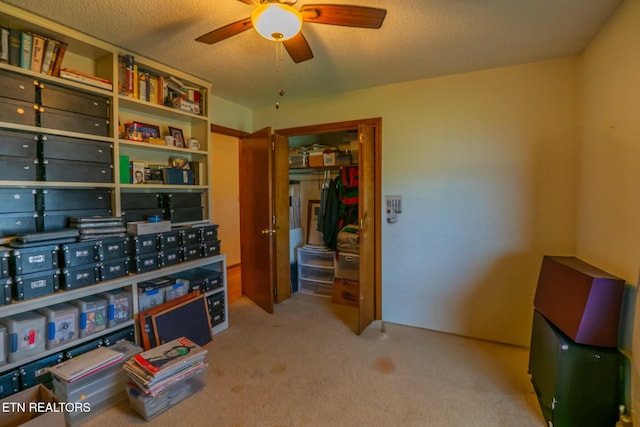 interior space with ceiling fan, carpet flooring, and a textured ceiling