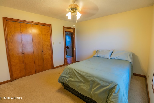 bedroom with baseboards, ceiling fan, a closet, and carpet floors
