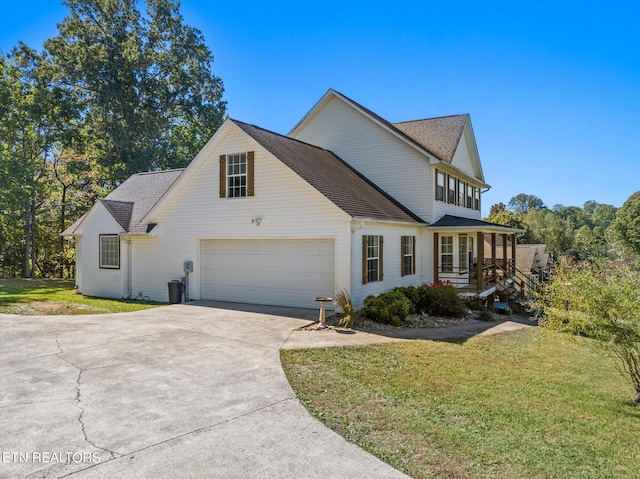 view of front facade featuring a front yard, covered porch, and a garage