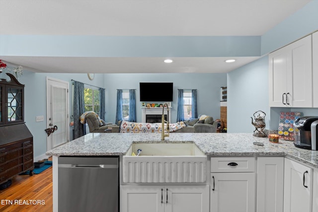 kitchen featuring white cabinetry, light hardwood / wood-style flooring, stainless steel dishwasher, and sink