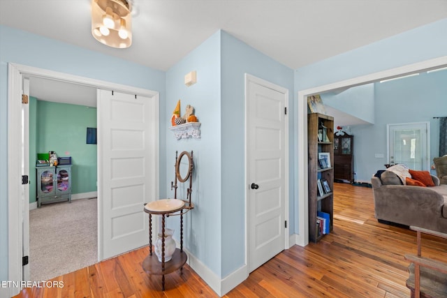 corridor with hardwood / wood-style flooring