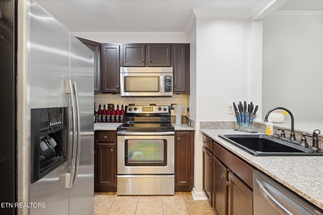 kitchen featuring crown molding, stainless steel appliances, sink, and light tile patterned floors