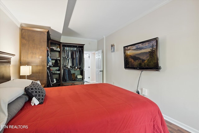 bedroom with a closet, ornamental molding, and wood-type flooring