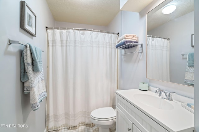 bathroom featuring vanity, toilet, and a textured ceiling