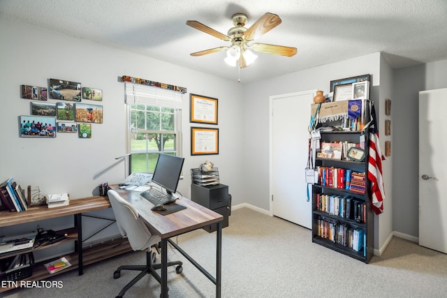 carpeted office space featuring ceiling fan and a textured ceiling