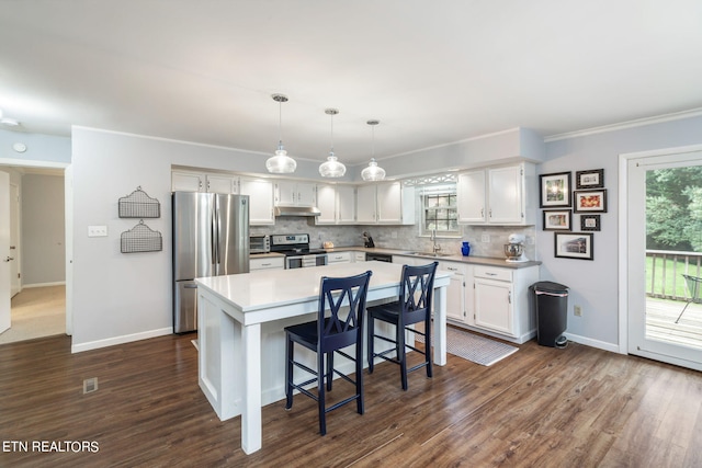 kitchen with sink, a center island, white cabinetry, stainless steel appliances, and dark hardwood / wood-style floors