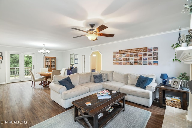 living room with crown molding, dark hardwood / wood-style floors, and ceiling fan with notable chandelier