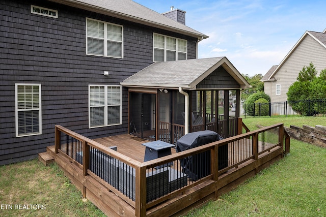 deck with a grill, a lawn, and a sunroom