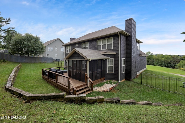 rear view of house with a yard and a sunroom