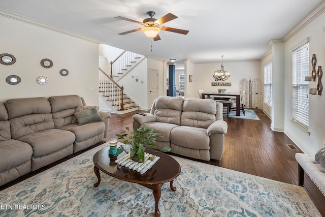 living room featuring ornamental molding, dark wood-type flooring, and ceiling fan with notable chandelier