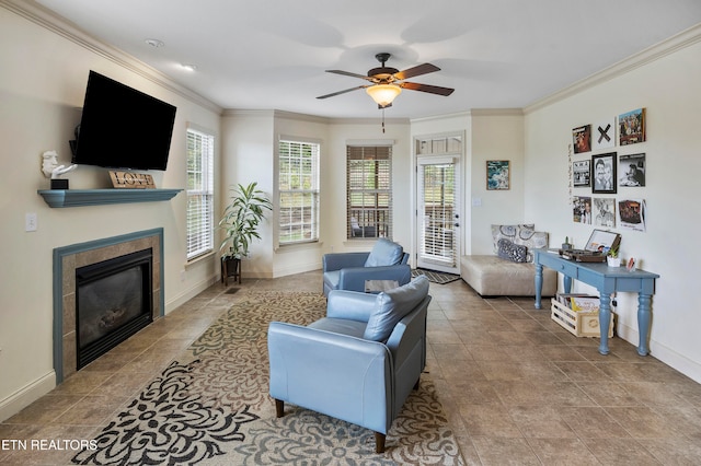 living room featuring ceiling fan, crown molding, and a fireplace