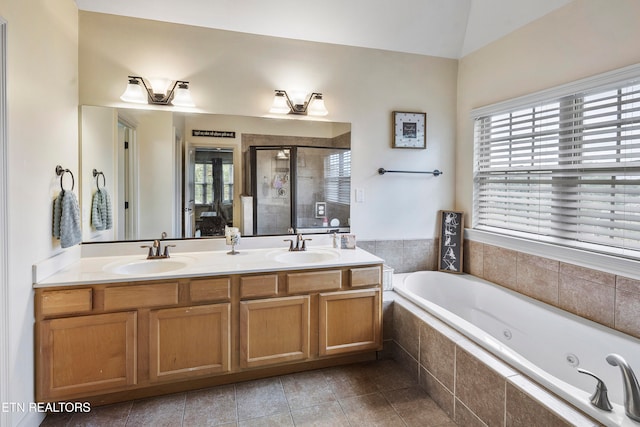 bathroom featuring vanity, independent shower and bath, tile patterned floors, and vaulted ceiling