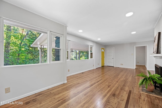 unfurnished living room featuring a brick fireplace and light wood-type flooring