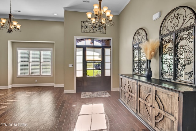 entrance foyer with a wealth of natural light, a chandelier, and dark hardwood / wood-style floors