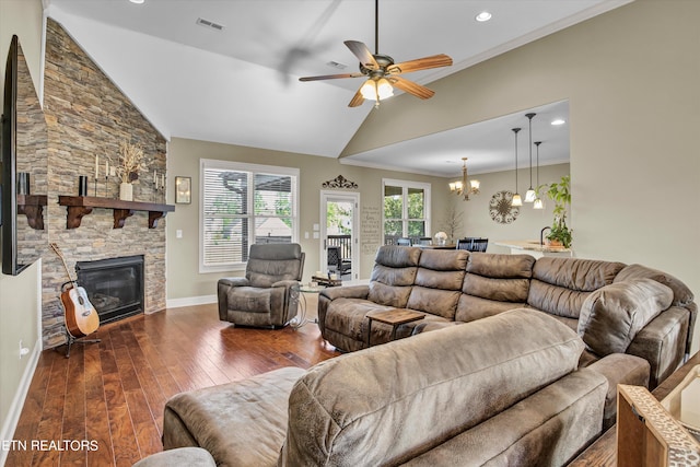 living room with high vaulted ceiling, dark wood-type flooring, ceiling fan with notable chandelier, a fireplace, and crown molding