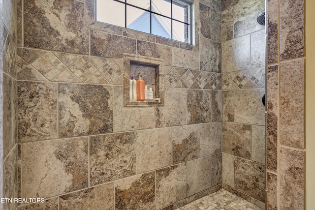 interior details featuring a tile shower