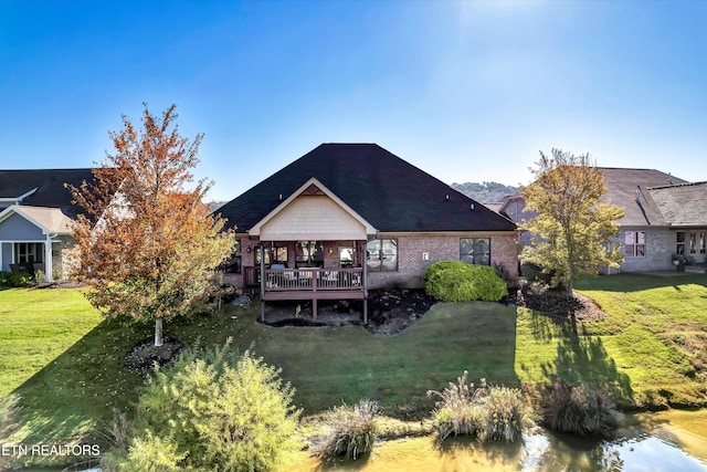 rear view of property featuring a wooden deck and a lawn