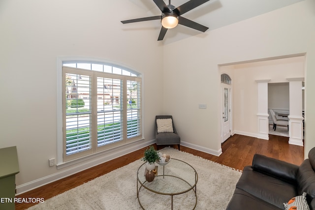 living room featuring dark wood-type flooring and ceiling fan