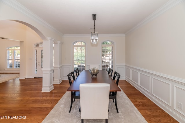 dining space featuring ornamental molding, a chandelier, ornate columns, and dark hardwood / wood-style flooring