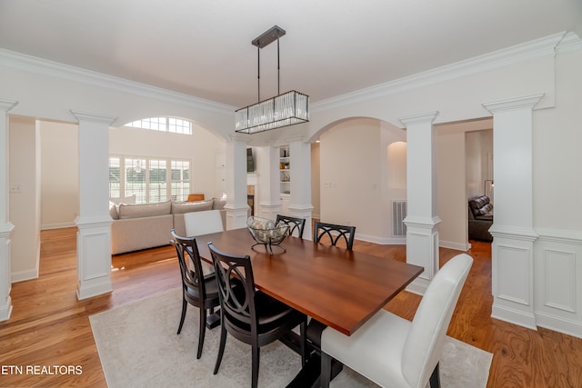 dining area featuring light hardwood / wood-style floors, ornamental molding, and a chandelier