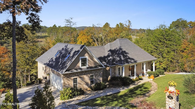 339 Eagles Rdg, Tazewell, TN 37879 - view of front facade with a porch, concrete driveway, brick siding, a wooded view, and a front yard