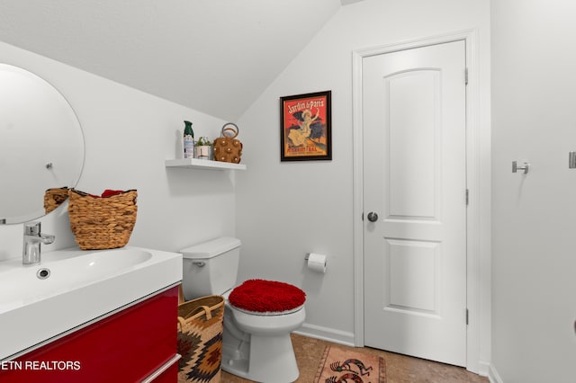 bathroom with vanity, toilet, tile patterned floors, and vaulted ceiling