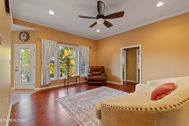 living room with ceiling fan, ornamental molding, and dark hardwood / wood-style flooring