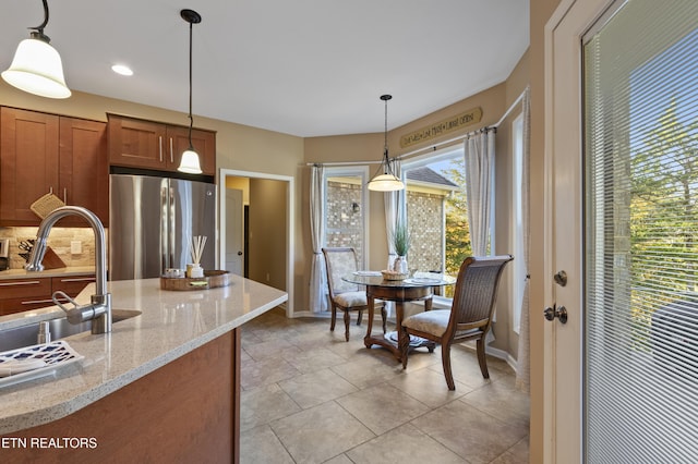 339 Eagles Rdg, Tazewell, TN 37879 - kitchen featuring freestanding refrigerator, a sink, brown cabinets, tasteful backsplash, and decorative light fixtures