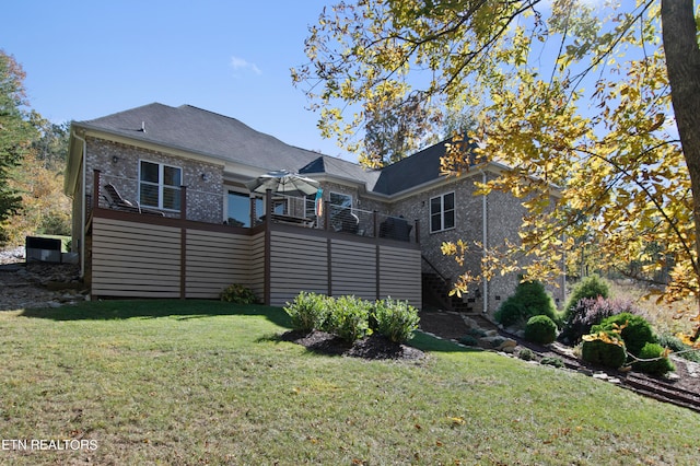 rear view of property with a lawn and a balcony