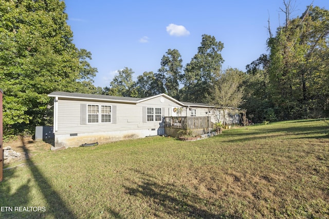 rear view of property with a deck and a lawn